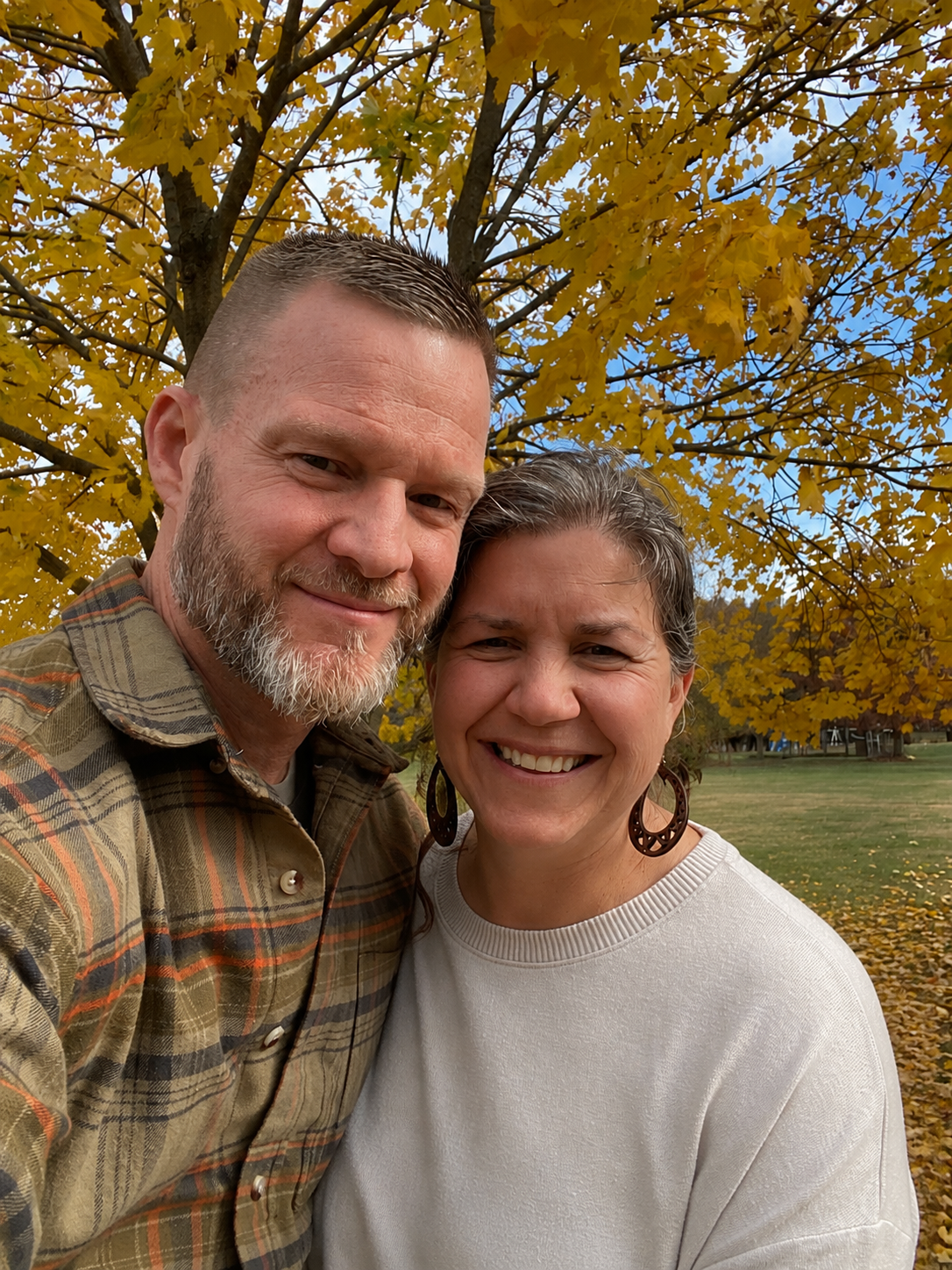 The family behind Hickory Home Partners standing outdoors beneath autumn trees
